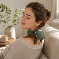 Woman relaxing on a sofa while using the ComfyHug massager on her neck